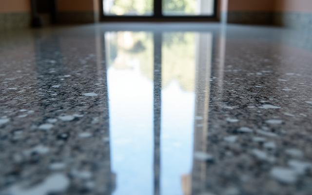 Close-up image of a perfectly polished marble floor reflecting light like liquid